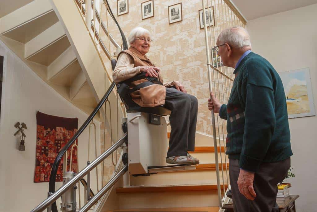 Älteres Paar an einer Treppe mit Treppenlift
